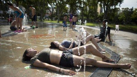 Teenagers cool down in a water fountain in Buenos Aires, 26/12/2013