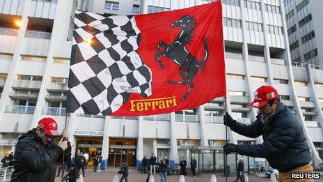 Fans fix a Ferrari flag in the ground in front of the CHU Nord hospital emergency unit in Grenoble (December 31, 2013)