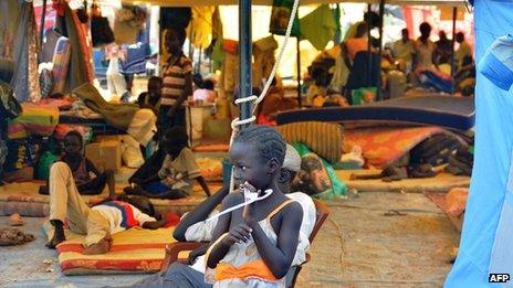 A South Sudanese child stands next to a tent within the United Nations Mission in Juba on 4 January 2014