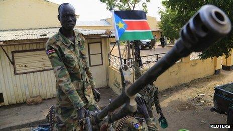 A South Sudan army soldier stands next to a machine gun mounted on a truck in Malakal town on 30 December 2013