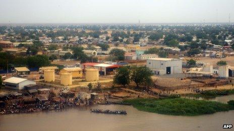 People gather on the banks of the White Nile in Malakal as a boat moves along the river. Photo: 12 January 2014