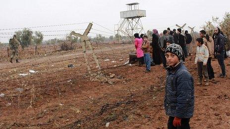Syrian refugees wait to cross border into Turkey. 13 Jan 2014