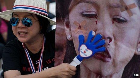 Anti-government protester in Thailand, with a defaced image of Ms Yingluck ( file picture)