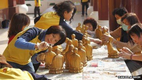 Volunteers clean Buddha statues at the Fo Guang Shan temple in Kaohsiung