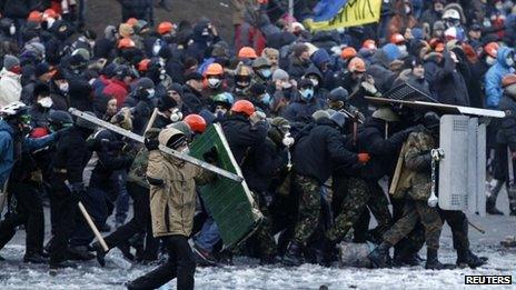 Pro-European integration protesters approach riot police during clashes in Kiev