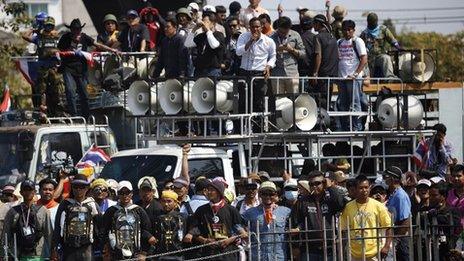Anti-government protesters lock their arms as they stand at the gates of the Army Club in Bangkok on 28 January 2014.