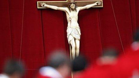 Priests stand in front of a crucifix (19 May 2013)