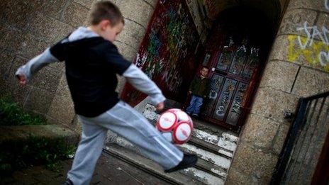 Child playing football in the Govan area of Glasgow