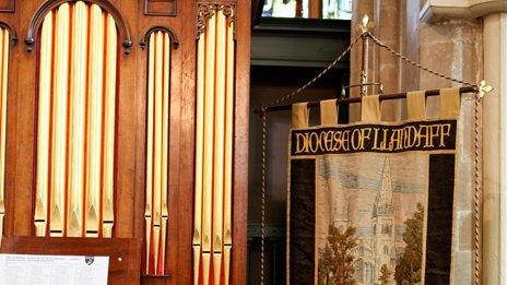 Organ and embroidered standard flag in interior of Llandaff Cathedral