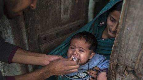 Polio worker vaccinates a Pakistani toddler (26 February 2014)