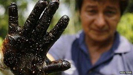 Environmentalist Donald Moncayo shows a glove covered in oil after testing an area in Lago Agrio, January 2011