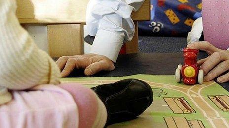 Adult playing with a child at a nursery