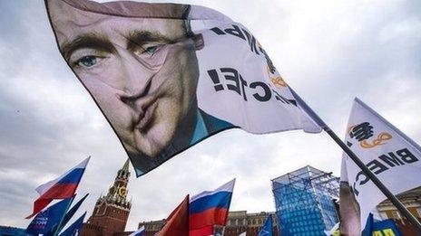 Pro-Kremlin activists wave a flag depicting President Vladimir Putin at rally at the Red Square in Moscow, on 18 March 2014, to celebrate the incorporation of Crimea