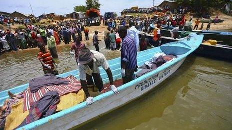 Volunteers prepare to carry the bodies of people killed after a boat disaster on Lake Albert in Uganda (24 March 2014)