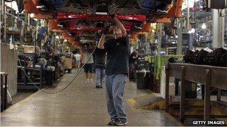 An employee works underneath a Ford Motor Co. Focus vehicle in Wayne, Michigan, on 7 October 2013