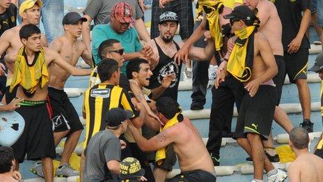 Fans of Uruguay's Penarol clash during the Uruguayan first division football derby against Nacional, at the Centenario stadium in Montevideo on November 24, 2013.