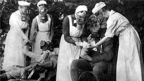Nurses in gas masks treat soldiers afters a gas attack