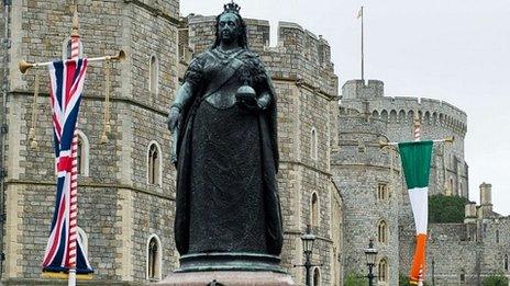 The Irish flag and the Union Flag are displayed on the roads next to a statue of Queen Victoria near Windsor Castle