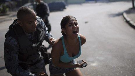 A woman screams while being detained during protests near the area recently occupied by squatters in Rio de Janeiro, on April 11, 2014
