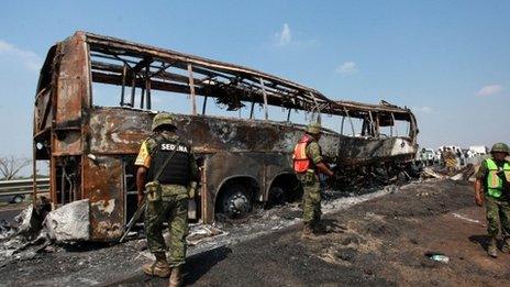 Soldiers guard the site where a passenger bus slammed into a broken-down lorry, on April 13, 2014.