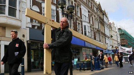 The Archbishop of Canterbury Justin Welby carries a cross through Dover, Kent,