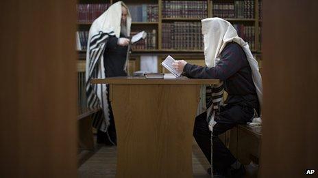 Two Jewish men read prayers in a synagogue in Donetsk, Ukraine,