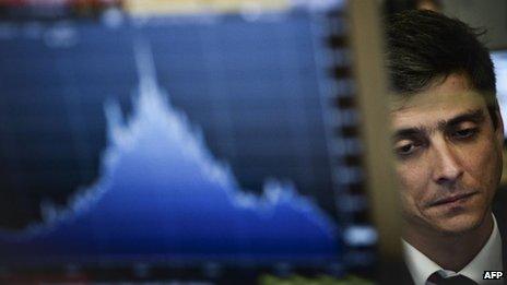 A trader works behind a computer screen in Lisbon during the auction of Portuguese Treasury Bills.