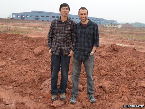 Prof Junchang Lu and Dr Steve Brusatte at construction site where dinosaur fossil discovered