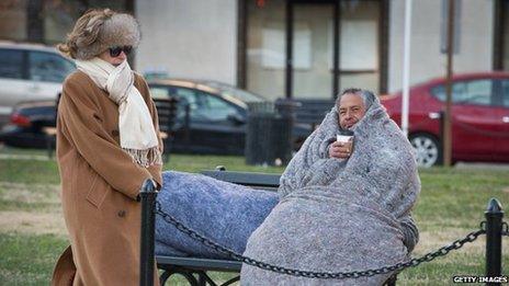 A woman walks by a homeless man in Washington DC