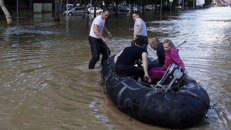 Volunteers use a rubber boat to evacuate residents from a flooded area in Obrenovac, some 30km (18 miles) south-west of Belgrade (18 May 2014)