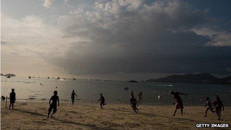 People playing frisby on a beach