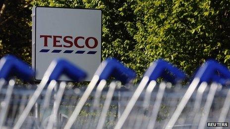 Shopping trolleys are seen lined up at a Tesco supermarket