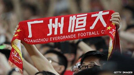 A fan holds up a Guangzhou Evergrande banner