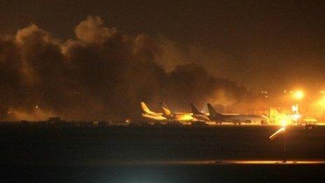Fire illuminates the sky above the Jinnah International Airport in Karachi where security forces are fighting with attackers, 8 June 2014