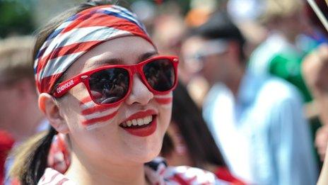 US soccer fan, wearing sunglasses, is smiling