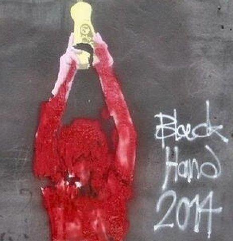 A piece of graffiti by Black Hand covered in red paint
