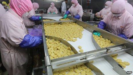 Workers processing meat at Shanghai Husi Food Co