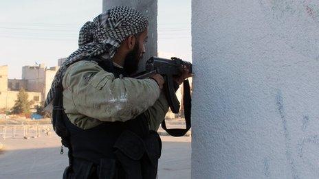 An opposition fighter guards against the Islamic State