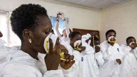 A World Health Organisation worker, (centre) trains nurses to use Ebola protective gear in Freetown, Sierra Leone (18 September 2014)