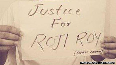 Photo of placard reads 'Justice for Roji Roy'