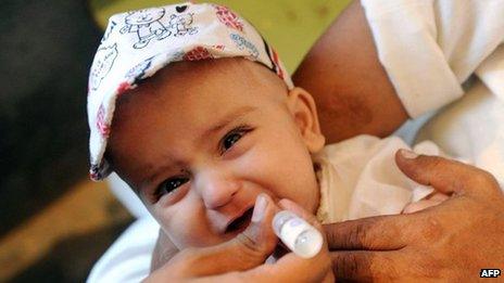 A health worker gives polio vaccine drops to a child in Peshawar, 2012