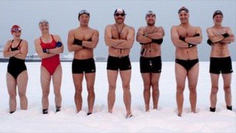 Swimmers stand in the snow on Brighton beach