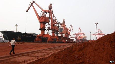 Bulldozer scoops soil containing various rare earth to be loaded on to a ship in China
