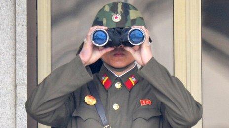 North Korean soldier looks through binoculars
