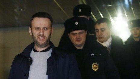 Anti-corruption blogger and liberal opposition leader Alexei Navalny (centre) is escorted into a police car outside Presnensky District Court, in Moscow (19 February 2015)