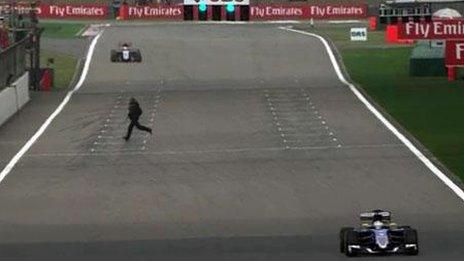 A fan runs across the start-finish straight during practice for the Chinese Grand Prix