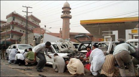 Pakistani media take cover outside a mosque in Lahore