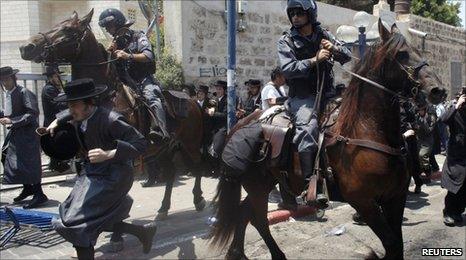 Mounted Israeli police officers try to disperse ultra-Orthodox Jews during a protest in Jaffa