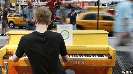 A tourist plays a street piano in New York's Times Square