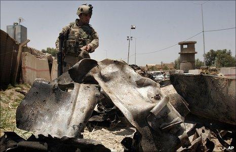 Iraqi soldier stands over wreckage at the site of the bombing